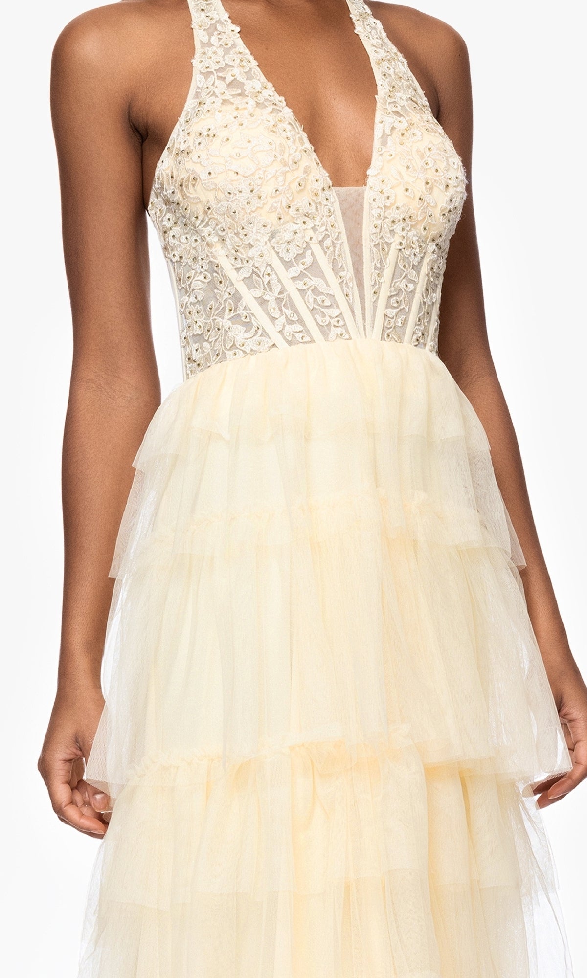 A woman in the Blondie Nites 5349BN Long Yellow Halter Prom Gown, featuring a lace bodice and tiered tulle skirt—ideal for an elegant evening look.